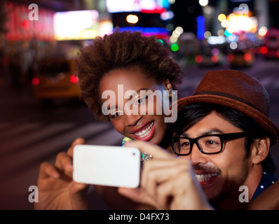 Couple taking pictures on city street