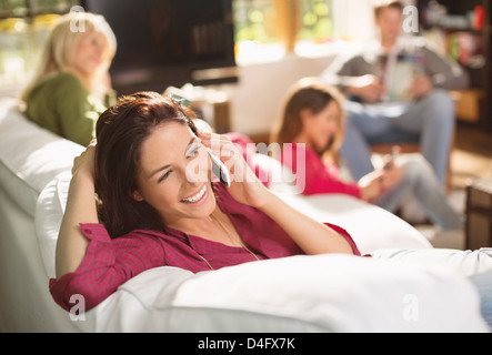Woman talking on phone on sofa Stock Photo
