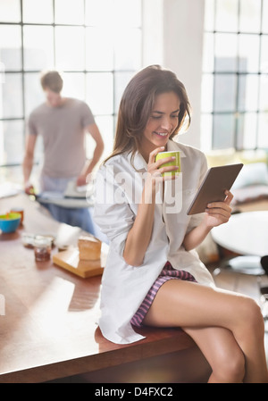 Woman using digital tablet in kitchen Stock Photo