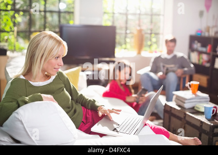 Woman using laptop on sofa Stock Photo