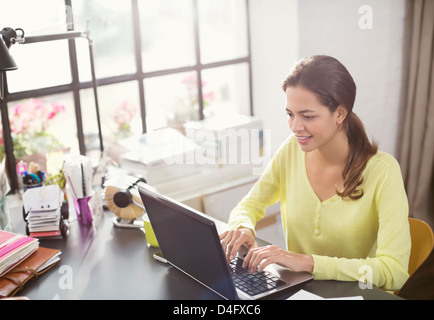 Woman using laptop at desk Stock Photo