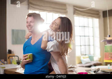 Smiling couple hugging in kitchen Stock Photo