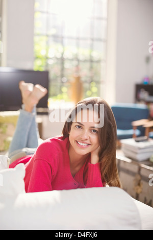Smiling woman laying on bed Stock Photo