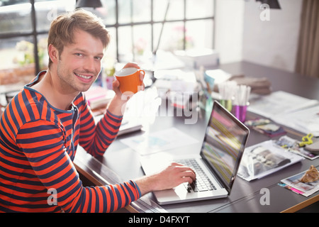 Man using laptop with cup of coffee Stock Photo
