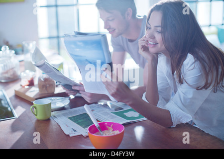 Couple reading magazines at breakfast Stock Photo