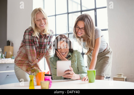 Women using digital tablet together Stock Photo