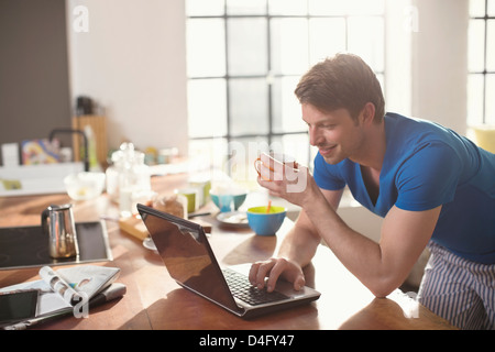 Man using laptop with cup of coffee Stock Photo