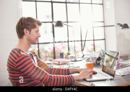 Man using laptop at desk Stock Photo