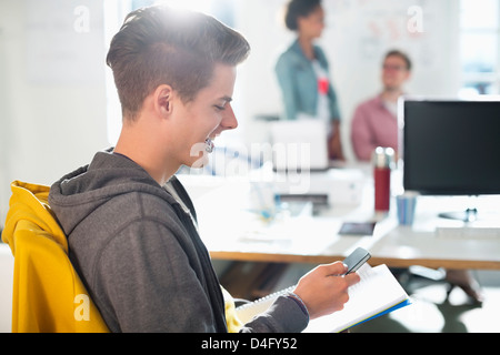 Man using cell phone in office Stock Photo