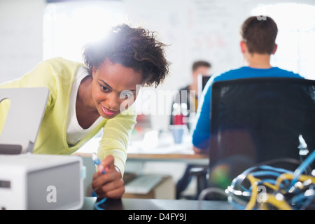 Businesswoman using printer at desk Stock Photo