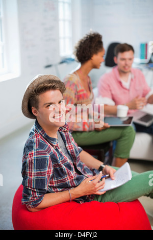 Businessman smiling in bean bag chair Stock Photo