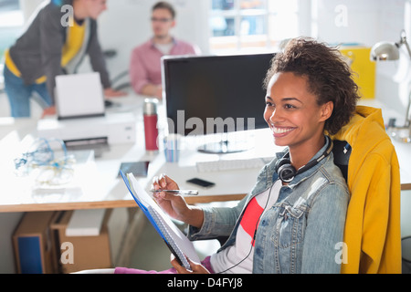 Businesswoman making notes at desk Stock Photo