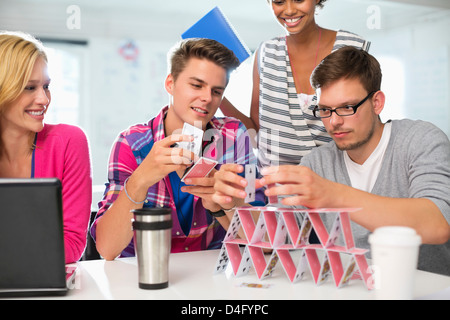 Business people making house of cards in office Stock Photo