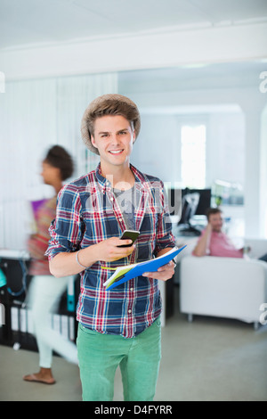 Businessman using cell phone in office Stock Photo