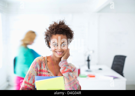 Businesswoman carrying folders in office Stock Photo