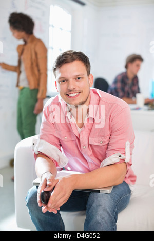 Businessman sitting on sofa in office Stock Photo