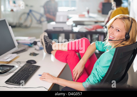 Businesswoman wearing headset at desk Stock Photo