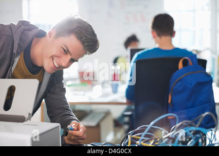 Businessman plugging in printer in office Stock Photo