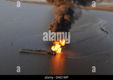 An oil pipeline burns after a collision with tug boat Shanon E. Setton March 13, 2013 near Bayou Perot 30 miles south of New Orleans, LA. The US Coast Guard is working to contain and clean up any oil that is leaking from the accident. Stock Photo