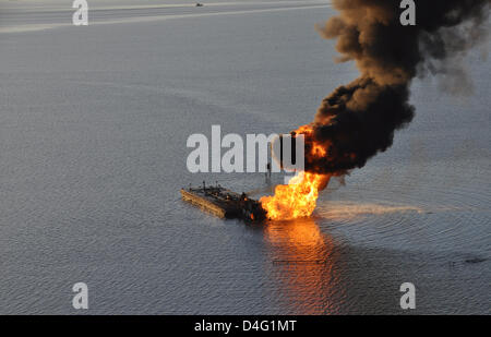 An oil pipeline burns after a collision with tug boat Shanon E. Setton March 13, 2013 near Bayou Perot 30 miles south of New Orleans, LA. The US Coast Guard is working to contain and clean up any oil that is leaking from the accident. Stock Photo