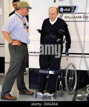 British Sir Frank Williams (R), Managing Director and Team Principal of Williams team chats standing with an unidentified person inside his team's garage before the first practice session at Marina Bay Street Circuit in Singapore, Singapore, 26 September 2008. Singapore will host Formula One's inaugural night Grand Prix street race on 28 September 2008. Photo: Frank May Stock Photo
