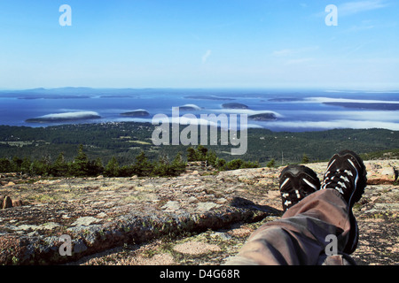 man feet with a stunning view of mountains and ocean Stock Photo