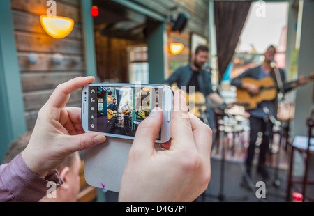 Using a smart phone to photograph a small band during the Winter Lights Festival, Reykjavik, Iceland Stock Photo