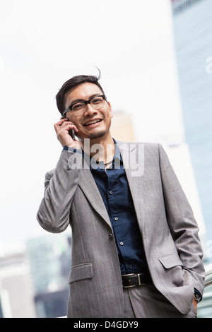 A young Chinese businessman with a smart phone, in Hong Kong. Stock Photo