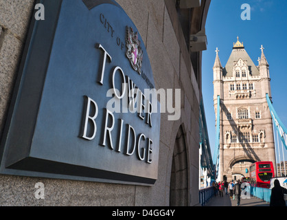 Tower Bridge and name plaque with traditional red bus in background Southwark London UK Stock Photo