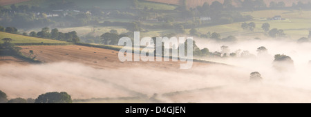 Mist covered rolling countryside near the village of Cadbury, Devon, England. Autumn (September) 2012. Stock Photo