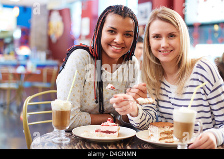 Image of two teenage girls spending time in cafe Stock Photo