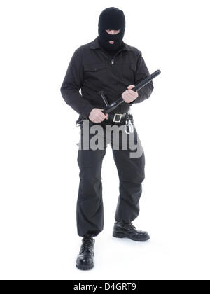 Antiterrorist police guy wearing black uniform and black mask holding firmly police club in both hands ready for action Stock Photo