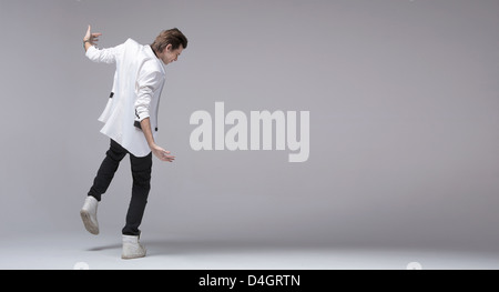 Handsome young man with jacket dancing alone Stock Photo