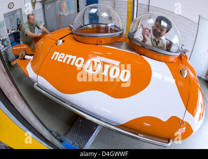 Divers Lutz Cordts (R) and Juergen Herrmann work on leisure submarine 'U-Boot Nemo 100' at the work shop of 'Nemo Tauchtouristik GmbH & Co KG' in Frankfurt Oder, Germany, 14 July 2008. The submarine addresses tourists who seek to discover the German and European underwater world. 'Nemo 100' features three glass cupolas granting an allround view for the two passengers. It can stay u Stock Photo