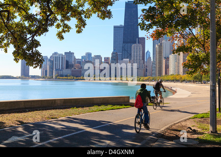 Cyclists riding along Lake Michigan shore with the Chicago skyline beyond, Chicago, Illinois, USA Stock Photo