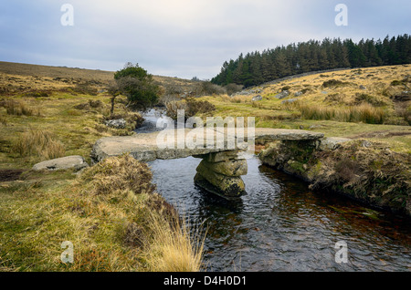 An ancient granite clapper bridge over Walla Brook near Scorhill on Dartmoor Stock Photo