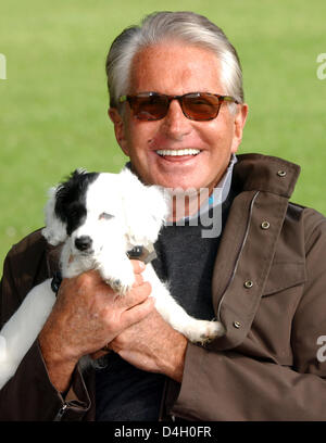 US-actor George Hamilton poses with his crossbreed dog 'Dodo' in Duesseldorf, Germany, 16 June 2008. Photo: Horst Ossinger Stock Photo