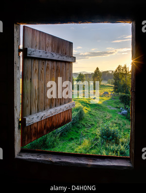 Wooden door open to sunlit landscape in Röste, Bollnäs, Hälsingland, Sweden, Europe Stock Photo