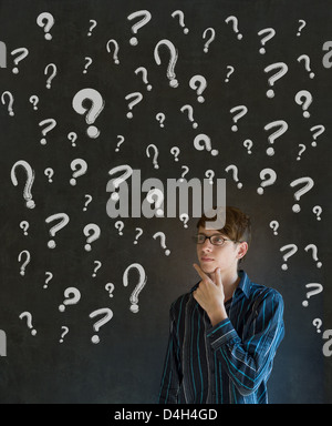 Thinking business man with chalk questions marks on blackboard background Stock Photo