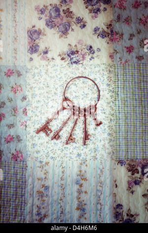 an old keyring with a bunch of keys on a vintage plaid Stock Photo