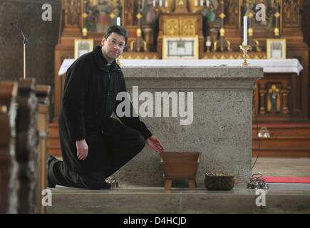 Pastor Thomas Rein points to the wooden crip, in which he had found a newborn a day before on 02 December at the Catholic Church St. Peter and Paul in Poettmes, Germany, 03 December 2008. The healthy baby boy was only a few hours old when Rein found him, said the police. A 38-year-old Romanian woman living in the region was identified to be the mother of the child. Her motives are  Stock Photo