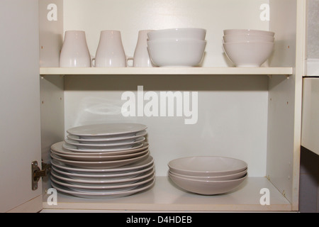 Plates and dishes in kitchen cupboard Stock Photo