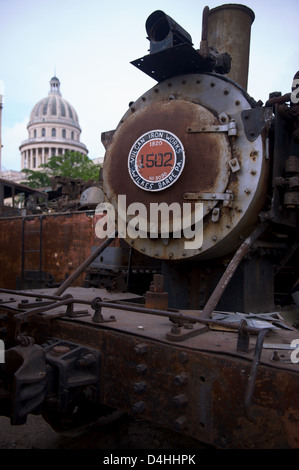Rusting steam trains in a yard in central part of Havana, Cuba. El Capitolio building in the background Stock Photo