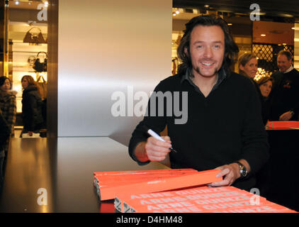 Belgian artist Arne Quinze signs parts of his artwork ?The Traveller? at the Louis Vuitton store in Munich, Germany, 24 January 2009. Quinze sold parts of his wooden sculpture to the benefit of the Peter Maffay Foundation. Photo: Felix Hoerhager Stock Photo
