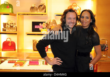 Belgian artist Arne Quinze and his girlfriend Barbara Becker (R) smile at the Louis Vuitton store in Munich, Germany, 24 January 2009. During the disassembly of his artwork ?The Traveller?, Quinze sold parts of his wooden sculpture to the benefit of the Peter Maffay Foundation. Photo: Felix Hoerhager Stock Photo