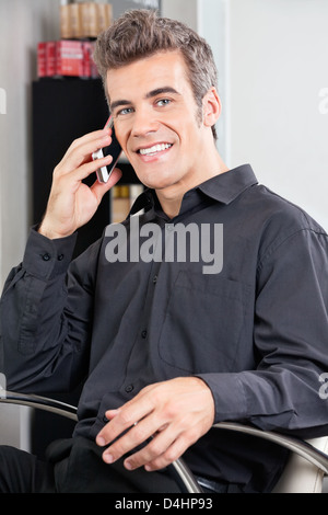 Male Customer Using Cellphone At Salon Stock Photo