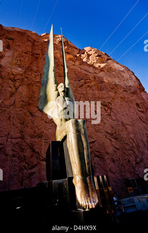 The setting sun illuminates one of the two bronze 'Angels Statues' by sculptor Oskar Hansen decorating Hoover Dam Stock Photo