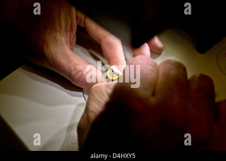 Wearing gloves, a laboratory technician prepares a cartridge case from a crime scene for forensic examination Stock Photo