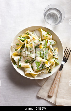 A plate of pappardelle pasta with creamy ricotta, baby spinach, fresh herbs and black pepper.