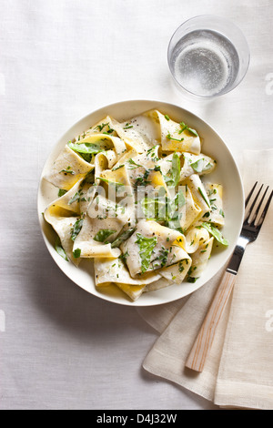 A plate of pappardelle pasta with creamy ricotta, baby spinach, fresh herbs and black pepper. Stock Photo